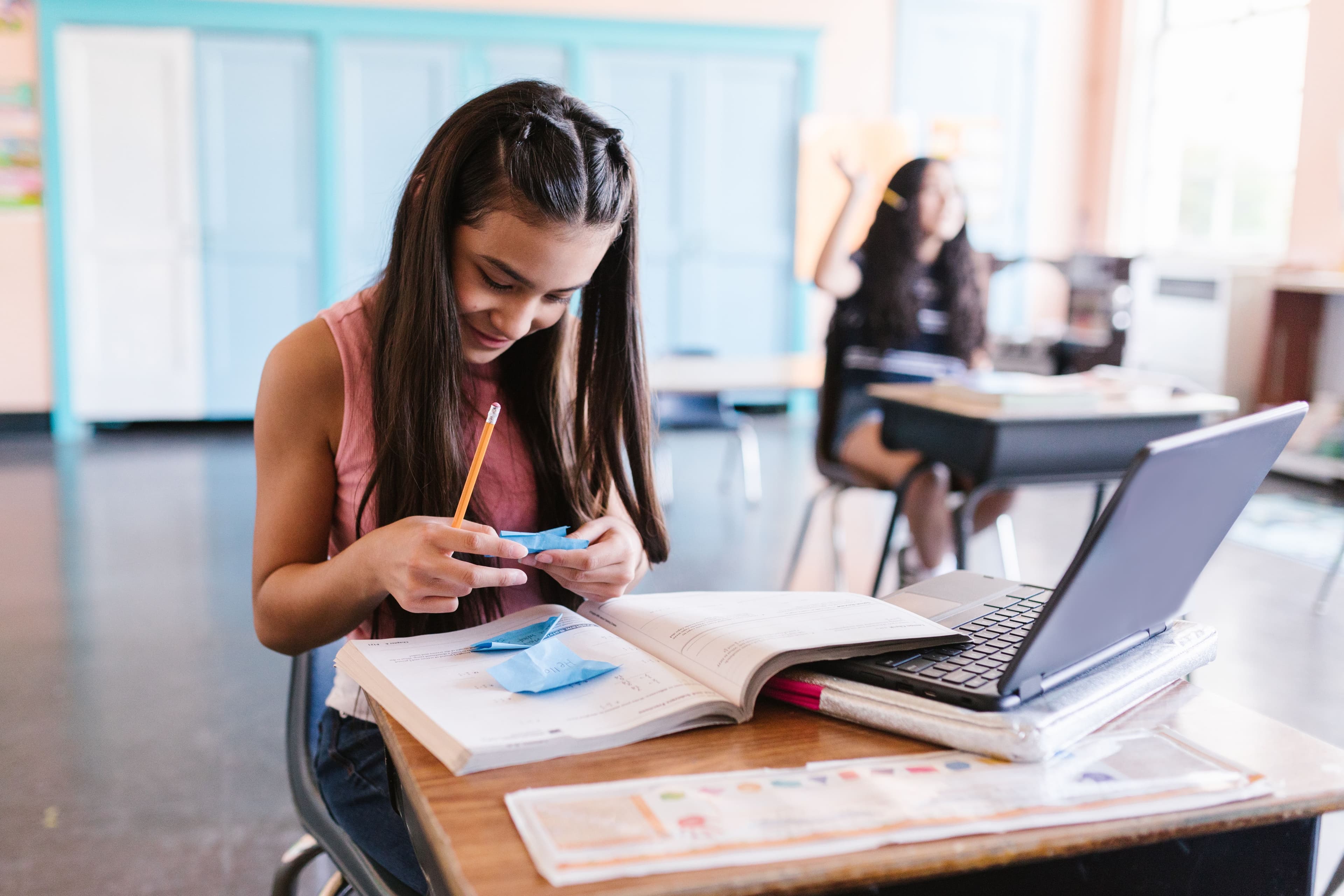 Student studying with laptop and textbook